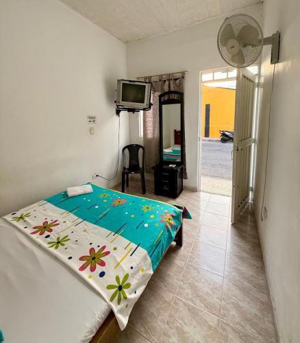 a bedroom with a bed and a tv in it at Hospedaje DJ in Buga