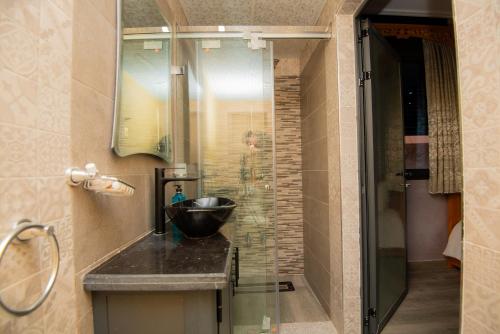 a bathroom with a sink and a glass shower at Relais Des Nomades in Tinerhir