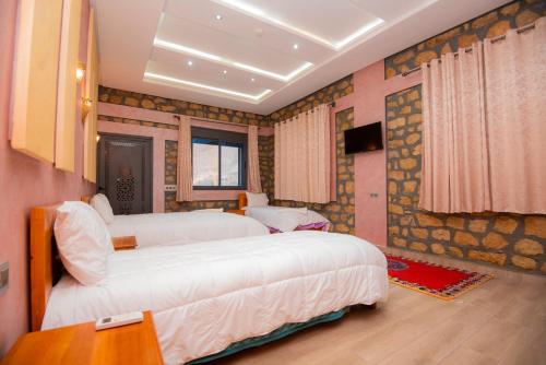 a bedroom with two beds and a couch at Relais Des Nomades in Tinerhir