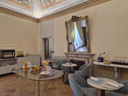 a room with a table and chairs and a mirror at Palazzo Brunamonti Boutique Hotel in Bevagna