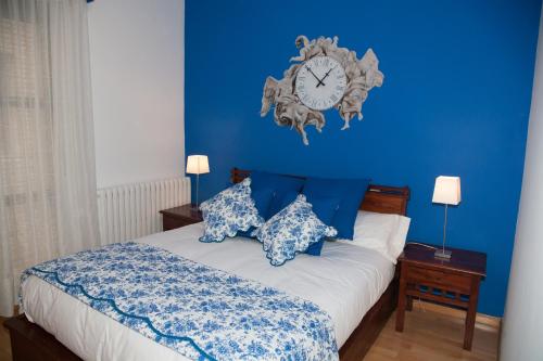 a blue bedroom with a bed with a clock on the wall at Lucero Dos Catedrales in Zaragoza