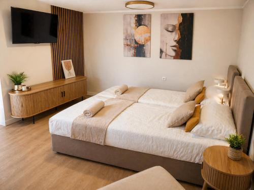a bedroom with a large bed and a flat screen tv at Lake House Mierzyn in Mierzyn