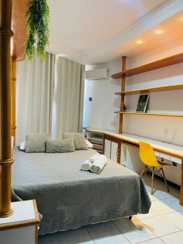 a room with two beds and a desk and a desk at Ap Beira mar na Orla in Aracaju
