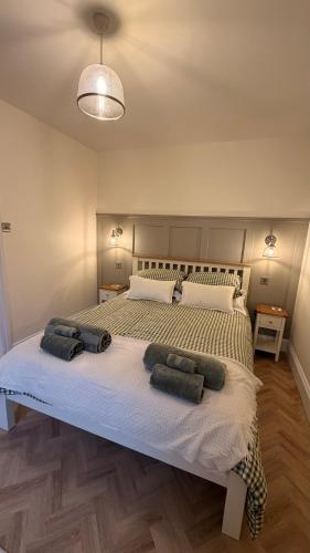 a bedroom with a large bed with two pillows on it at Hollylea Cottage - New Forest in Godshill