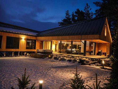 a large wooden house with a courtyard at night at Chalet Beyond in Veľká Lomnica