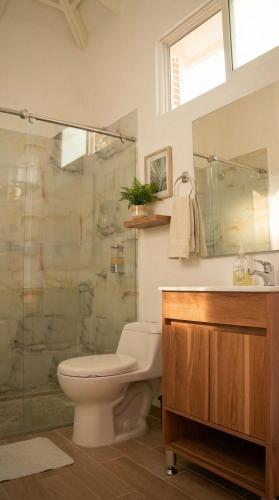 a bathroom with a toilet and a glass shower at Acaymas Club in Ricaurte