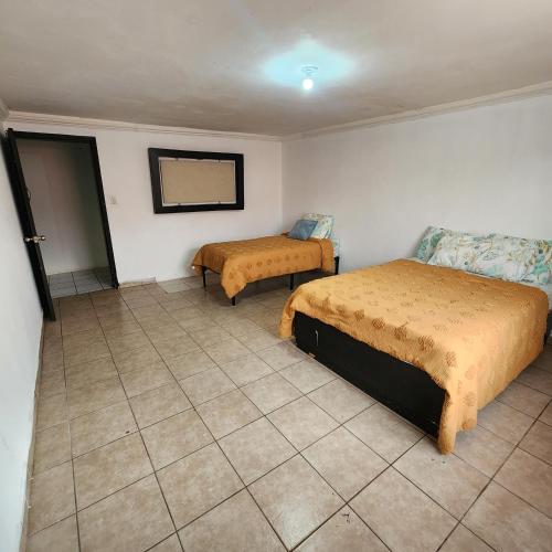 a bedroom with two beds and a tiled floor at Casa Morada in San Felipe