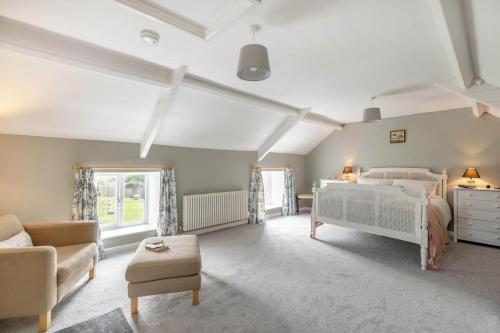 a bedroom with a white bed and a couch at 2 Bed in Chideock oc-c36616 in Chideock