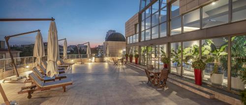 a balcony of a building with chairs and umbrellas at Ankara HiltonSA in Ankara