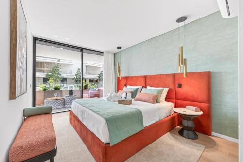 a bedroom with a large bed with a red headboard at Riva Waterfront in Olhão