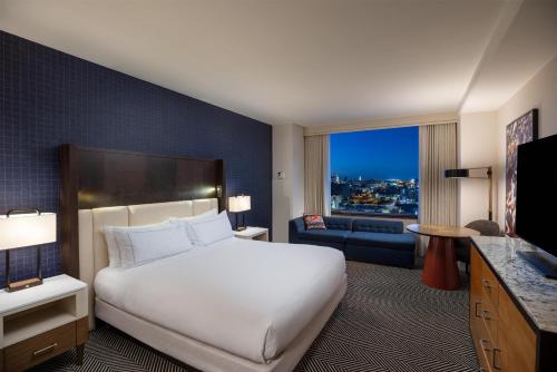 a bedroom with a large white bed and a living room at Hilton Austin in Austin
