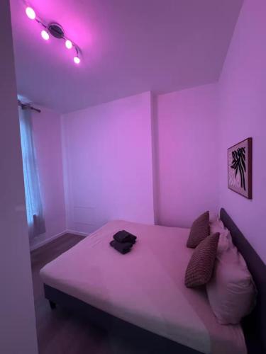 a bedroom with a bed with purple lights on it at Stylish 1BR Apartment with Sofa Bed in the Heart of Liège in Liège