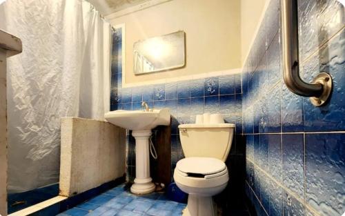 a blue tiled bathroom with a toilet and a sink at Casa Morada in San Felipe