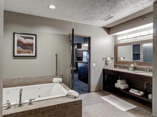 ein großes Badezimmer mit Badewanne und Waschbecken in der Unterkunft DoubleTree by Hilton Bloomington in Bloomington