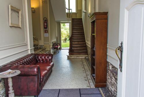 a living room with a leather couch in a hallway at Hotel Saint Georges in Mons