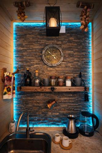 a kitchen with a sink and a clock on a brick wall at Alashkert Guesthouse Premium and Cozy Studios in Gyumri in Gyumri