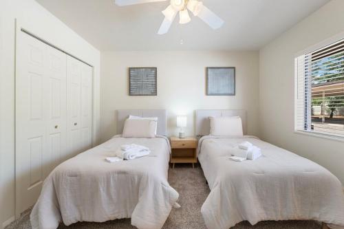 two beds in a room with white walls and a window at Sedona 2BR Near Trails & Shops in Sedona