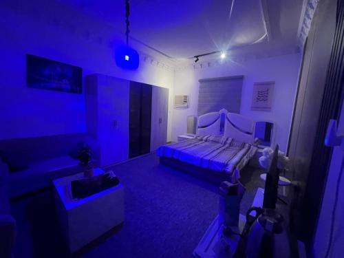 a room with a bed and a couch in a blue room at استوديو 104 in Tabuk