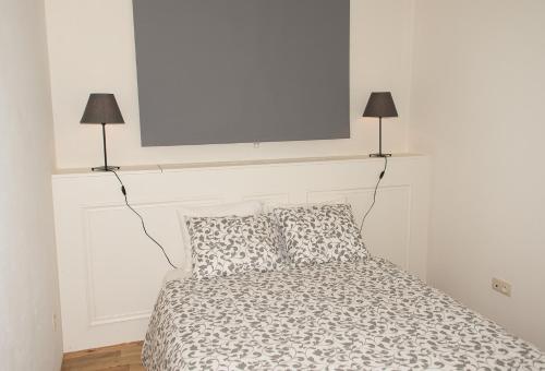 a bedroom with a bed with two lamps on the wall at Hotel Saint Georges in Mons