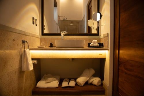 a bathroom with a sink and a mirror and towels at Mirtala Hotel Boutique in Guanajuato