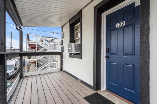 a blue door on a balcony with a boat at Boutique Hotel Style Steps to Boardwalk in Seaside Heights