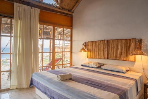 a bedroom with a large bed with a large window at kontiki in Máncora
