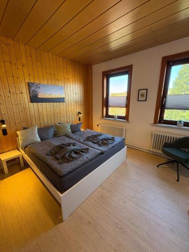 a bedroom with a bed in a room with wooden walls at Pension moos & morgenrot - St Andreasberg in Sankt Andreasberg