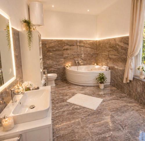 a bathroom with a tub and a toilet and a sink at Relax Villa with Pool in Bihać
