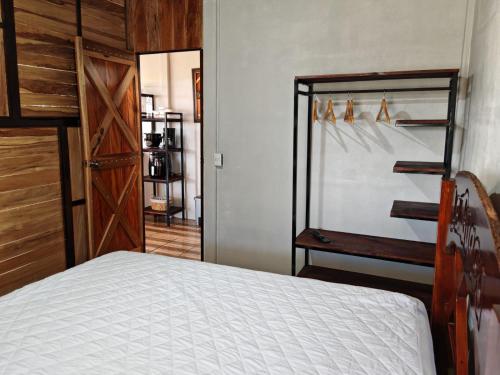 a bedroom with a bed and a closet and a door at Hospedaje La Guaca in Bagaces