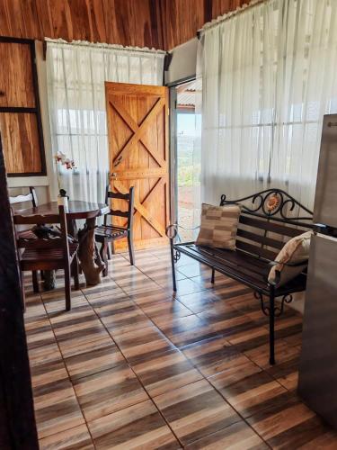a room with a bench and a table and a door at Hospedaje La Guaca in Bagaces
