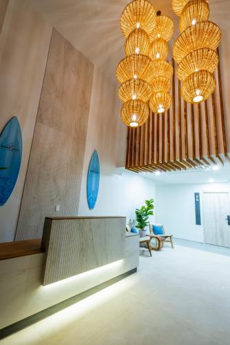 a lobby with two chandeliers and a reception desk at Mono Luxe Villas in Tamarindo