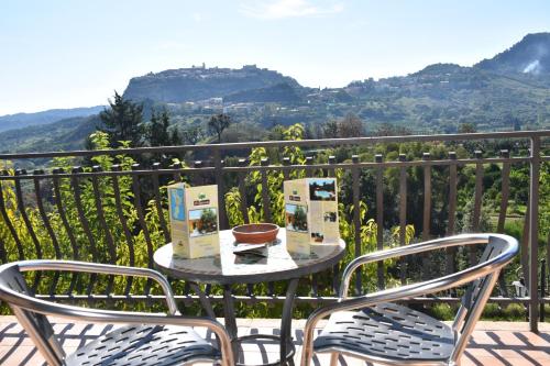 a table and chairs on a balcony with mountains at Azienda Agrituristica Biologica Il Querceto in Santa Severina