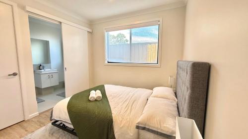 a bedroom with a bed with two shoes on it at Binshaw Main House in Glenlee Station