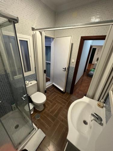 a bathroom with a toilet and a sink and a shower at Apartamento La Línea 1 in La Línea de la Concepción