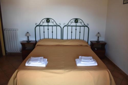 a bed with two white towels on top of it at Azienda Agrituristica Biologica Il Querceto in Santa Severina