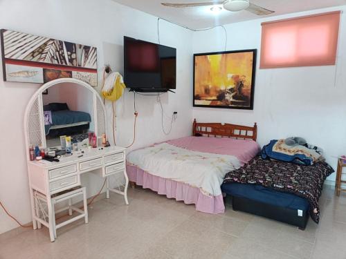 ein Schlafzimmer mit einem Bett, einem Schreibtisch und einem Spiegel in der Unterkunft Seidy del Mar in Telchac