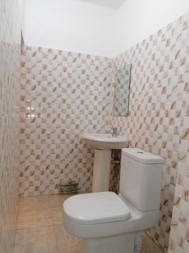 a bathroom with a toilet and a sink at O'soho GarDens BingerVille in Bingerville