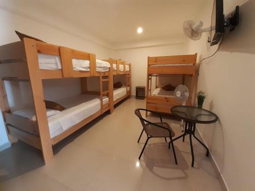 a room with two bunk beds and a table at Hotel Ocean Beach Paracas in Paracas