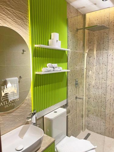 a bathroom with a toilet and a green wall at Atlantis Hotel in Cairo