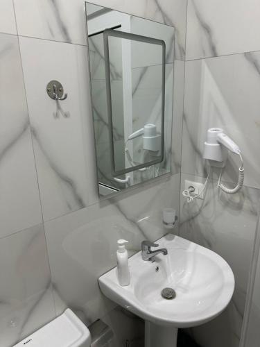a white bathroom with a sink and a mirror at Visi Villa Berat in Berat