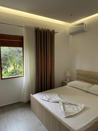a bedroom with a white bed with a window at Visi Villa Berat in Berat