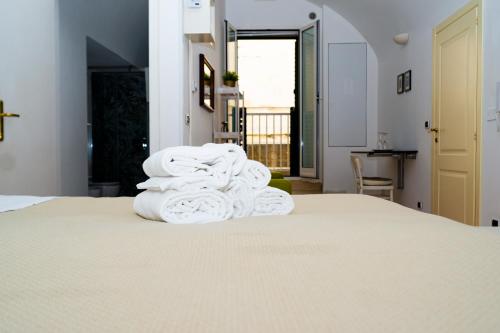 a stack of towels sitting on top of a bed at La Torre e il Mare - Room 3 by StHey in Monopoli