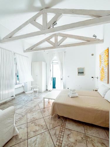 a white bedroom with a large bed and a table at La Torre e il Mare - Room 3 by StHey in Monopoli