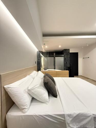 a bedroom with a white bed with pillows on it at Hotel Balcones in La Hormiga