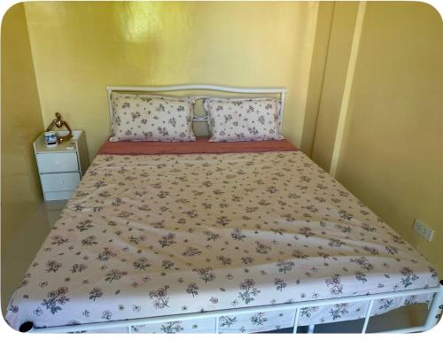 a bed in a bedroom with a bedspread with flowers at Peipers Inn in Panglao Island