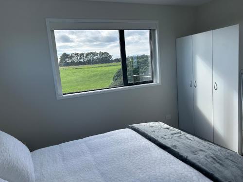 a bedroom with a bed and a window at Blacksmith's Rest in New Plymouth