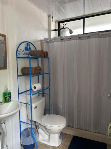 a bathroom with a toilet and a shower curtain at Casa Mate y Mar in Punta Leona
