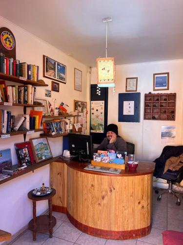 a woman sitting at a counter in a book store at Hostal El Punto in La Serena
