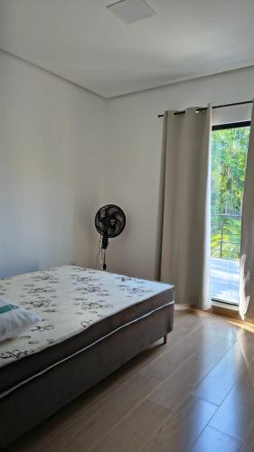 a bedroom with a bed and a large window at Sítio Belo Vale in Cataguases
