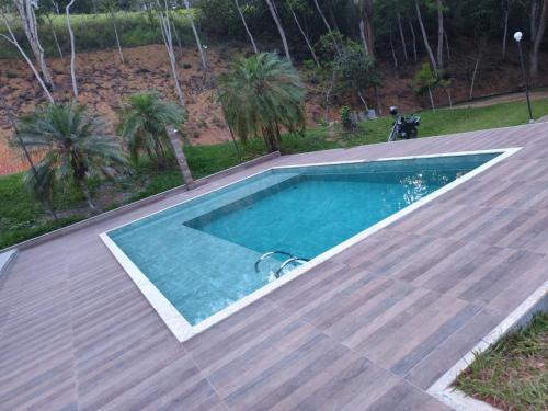 a swimming pool on top of a wooden deck at Sítio Belo Vale in Cataguases